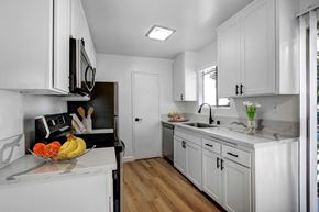Los Angeles apartment for rent - a kitchen with white cabinets and a bowl of fruit on the counter