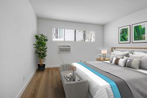 Los Angeles apartment for rent - a bedroom with white walls and a large bed with a blue blanket