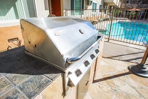 Sherman Oaks apartment for rent - A silver barbecue grill is on a patio next to a pool.
