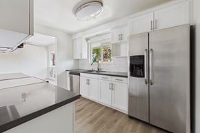 Newport Beach apartment for rent - A modern kitchen with a stainless steel refrigerator and white cabinets.