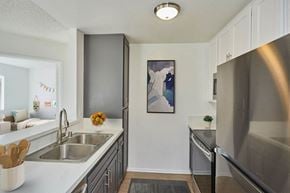 Los Angeles apartment for rent - A kitchen with a stainless steel refrigerator and a painting of a woman on the wall.