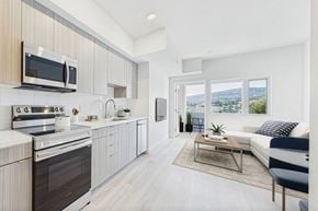 San Pedro apartment for rent - A modern kitchen with a stove top oven and microwave above it.
