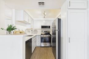 Burbank apartment for rent - A modern kitchen with white cabinets and stainless steel appliances.