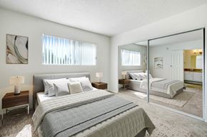 Reseda apartment for rent - A bedroom with a large bed and a mirrored closet door.