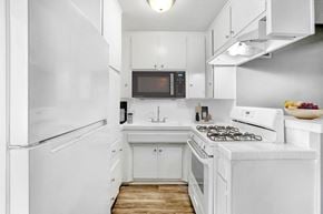 North Hollywood apartment for rent - a white kitchen with a stove and a refrigerator