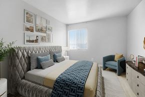 Van Nuys apartment for rent - A bedroom with a large bed and a blue chair.