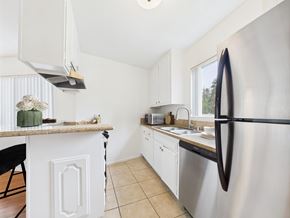 Los Angeles apartment for rent - A kitchen with a stainless steel refrigerator and white cabinets.