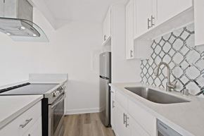 Marina Del Rey apartment for rent - A kitchen with white cabinets and a black stove top oven.