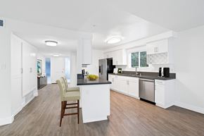 Newport Beach apartment for rent - A kitchen with white cabinets and a wooden floor.