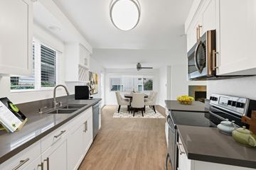 Newport Beach apartment for rent - A modern kitchen with white cabinets and a wooden floor.