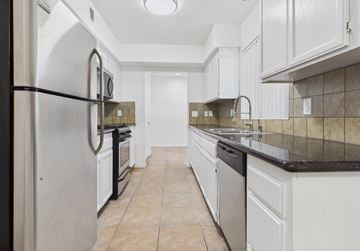 Los Angeles apartment for rent - A kitchen with white cabinets and a black fridge.