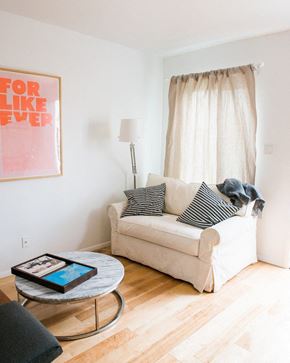 Los Angeles apartment for rent - a living room with a couch and a table with a tablet on it