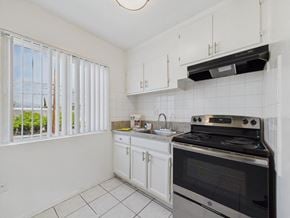 Arleta apartment for rent - A kitchen with white cabinets and a black stove top oven.