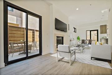 Tarzana apartment for rent - A modern living room with a white couch and a television mounted on the wall.