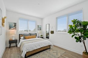 Bellflower apartment for rent - a bedroom with a bed and two windows