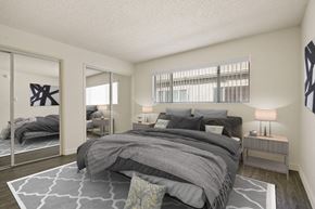 Los Angeles apartment for rent - A bedroom with a large bed and a mirror on the wall.