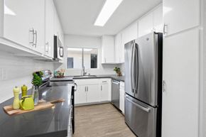 Burbank apartment for rent - A modern kitchen with a stainless steel refrigerator and white cabinets.