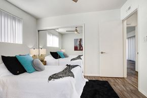 Los Angeles apartment for rent - A bedroom with a white bed and a black rug.