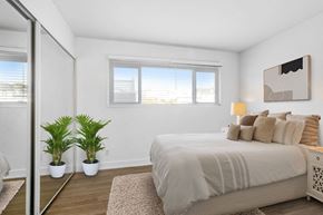 Los Angeles apartment for rent - A bedroom with a large bed and two potted plants.