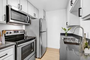 Los Angeles apartment for rent - A modern kitchen with stainless steel appliances and white cabinets.
