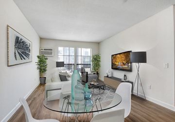 North Hollywood apartment for rent - A living room with a glass table and white chairs.