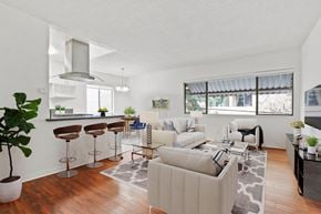 Beverly Hills apartment for rent - the living room and kitchen of an apartment with white couches and stools
