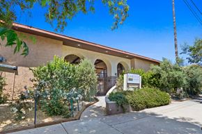 Canoga Park apartment for rent - a building with a sign in front of it and trees