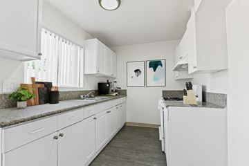 Canoga Park apartment for rent - A kitchen with white cabinets and a grey countertop.