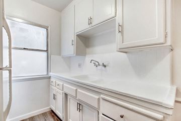 Los Angeles apartment for rent - A white kitchen with a refrigerator, cabinets, and a countertop.