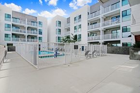 Reseda apartment for rent - an apartment building with a fence and a pool in front of it