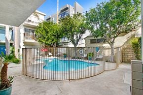 Los Angeles apartment for rent - A pool surrounded by a fence and trees.