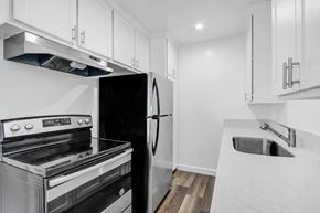Van Nuys apartment for rent - a kitchen with white cabinets and stainless steel appliances