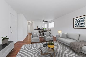 Los Angeles apartment for rent - A living room with a grey couch, a coffee table, and a dining table with chairs.