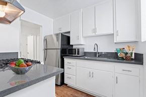 Los Angeles apartment for rent - a kitchen with white cabinets and a stainless steel refrigerator
