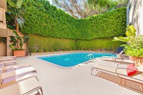 Brentwood apartment for rent - A pool surrounded by a green hedge.