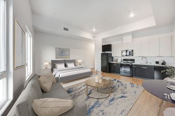 Los Angeles apartment for rent - A modern living room with a grey couch and a bed in the background.