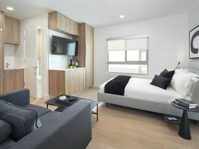 Los Angeles apartment for rent - A modern bedroom with a large bed and a grey couch.