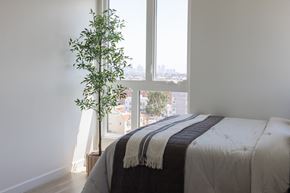 Los Angeles apartment for rent - A bedroom with a bed and a plant by the window at Skylar At Sunset Apartments, Los Angeles, California