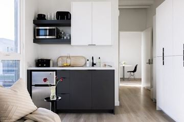 Los Angeles apartment for rent - A modern kitchen with white cabinets and a black fridge.