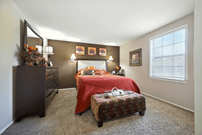 Indianapolis apartment for rent - Bedroom in a 2-bedroom Ashton Pointe apartment, featuring carpeted flooring and natural light streaming through a window.