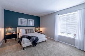 Bloomington apartment for rent - Master bedroom with accent wall and natural light at Woodbridge of Bloomington Apartments, Indiana, 47408