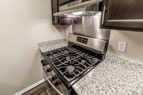 Bloomington apartment for rent - Gas range cooktop with stainless steel hood at Woodbridge of Bloomington Apartments, Bloomington, IN 47408