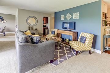 Indianapolis apartment for rent - A living room with a grey couch and a yellow and white chair.
