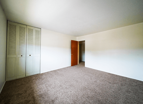 Bedford apartment for rent - Bedroom with a closet in a 2-bedroom townhome at Rainbow Hills Apartments, featuring a spacious layout.