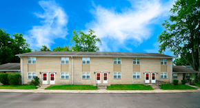 Bedford apartment for rent - Apartment building with red doors and windows.