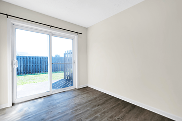 Clarksville apartment for rent - an empty living room with a sliding glass door and wood flooring