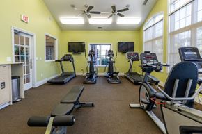 Zionsville apartment for rent - A gym with treadmills, elliptical machines, and a fan.