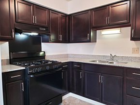 Indianapolis apartment for rent - Modern kitchen with dark wood cabinets and granite countertops at Carriage House West Apartments, Indianapolis, 46224