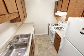 Indianapolis apartment for rent - 2 bedroom apartment kitchen with white appliances and brown cabinets at Woodbridge Apartments