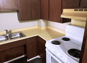 Marshall apartment for rent - A white stove is in a kitchen with wooden cabinets.